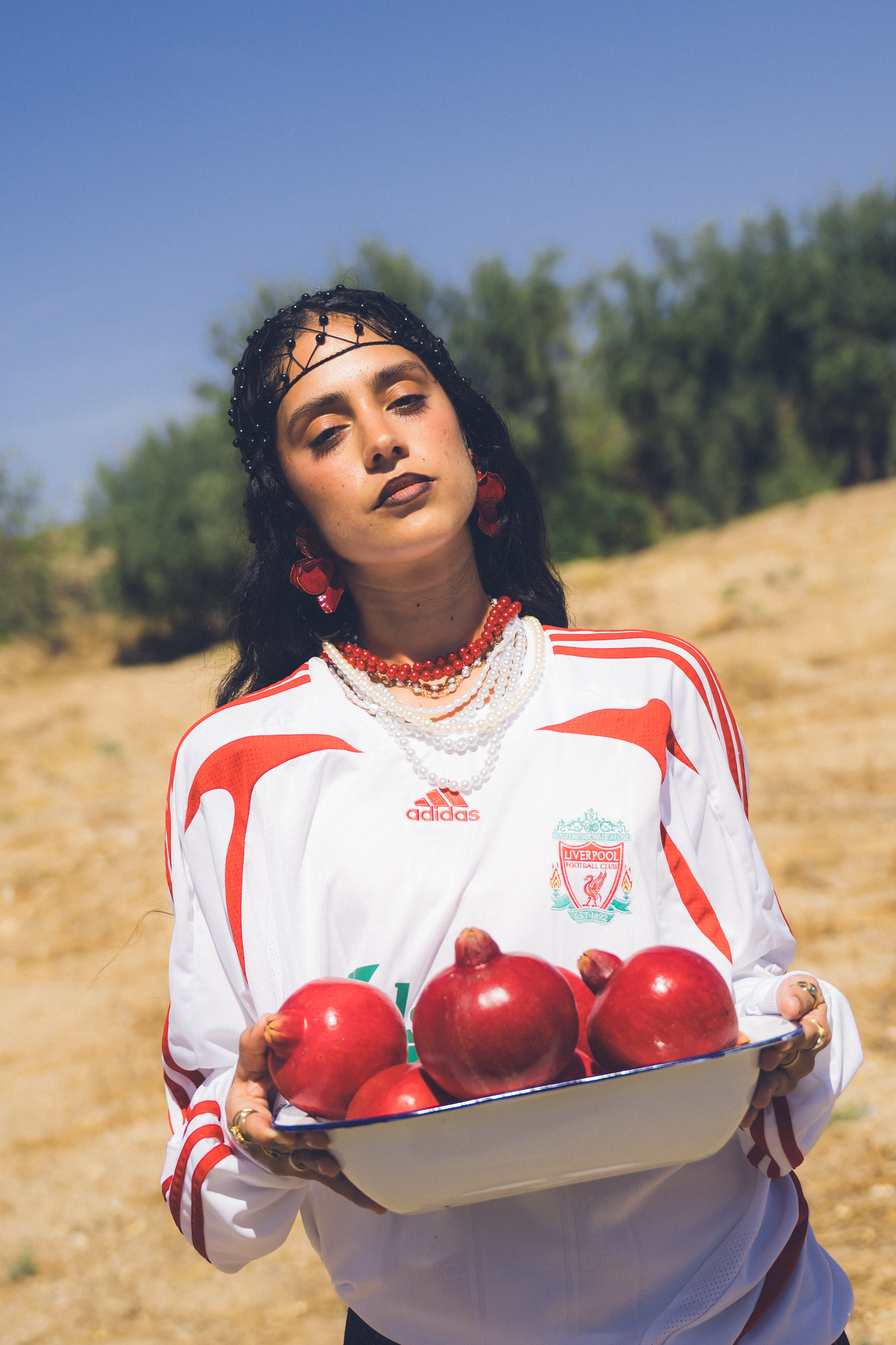 Modelo en un entorno rural sosteniendo un cuenco con frutos rojos.