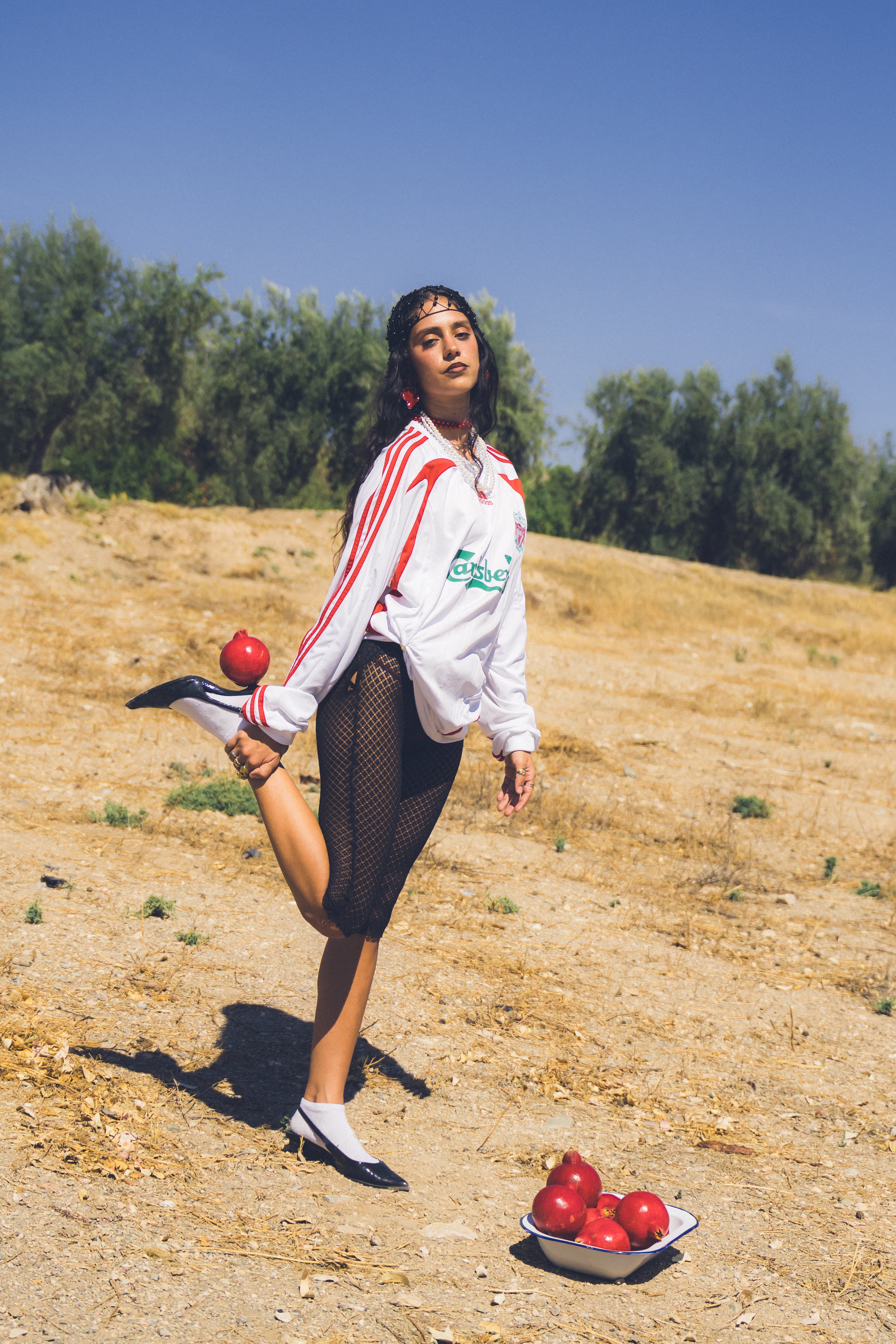 Modelo en un entorno rural sosteniendo un cuenco con frutos rojos en una actitud contemplativa.