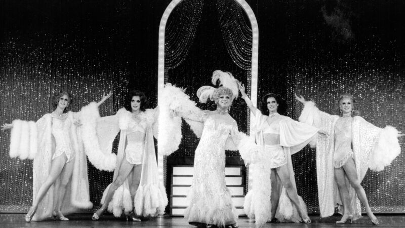 Escena de espectáculo drag en ambiente de cabaret y teatro