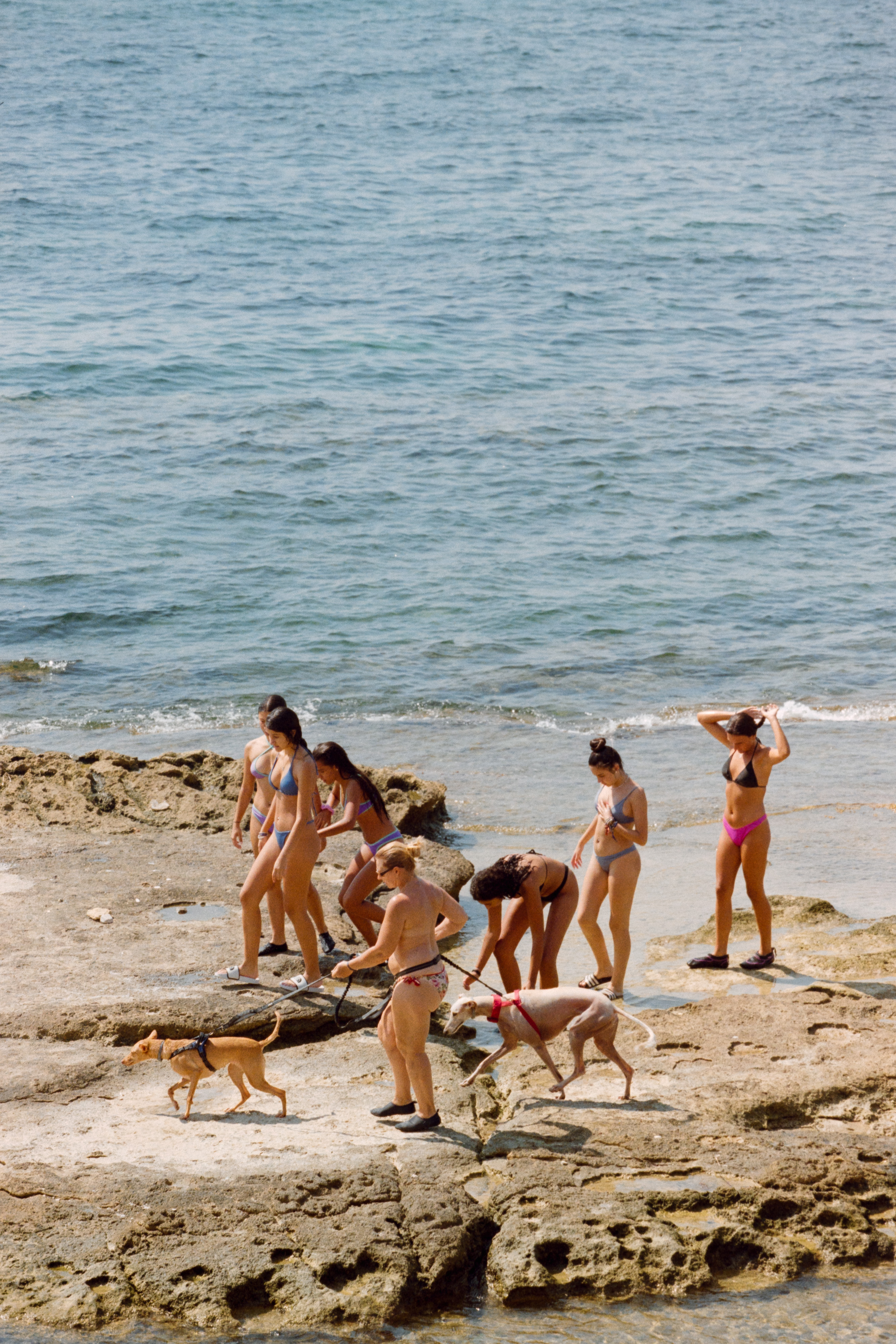 Bañistas caminando junto al mar en la costa de Alicante fotografiados en película analógica
