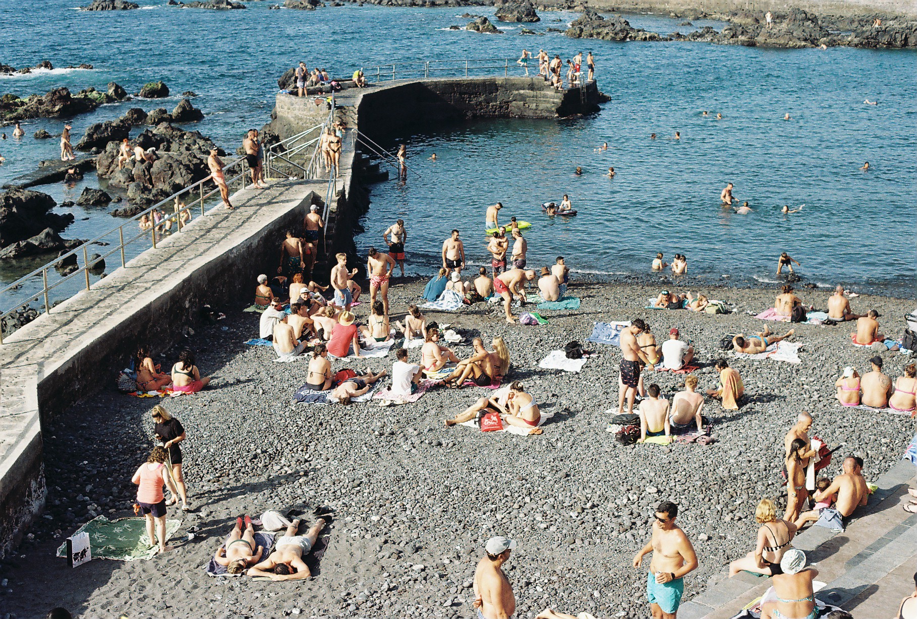 Personas descansando en la playa bajo la luz del atardecer en Tenerife