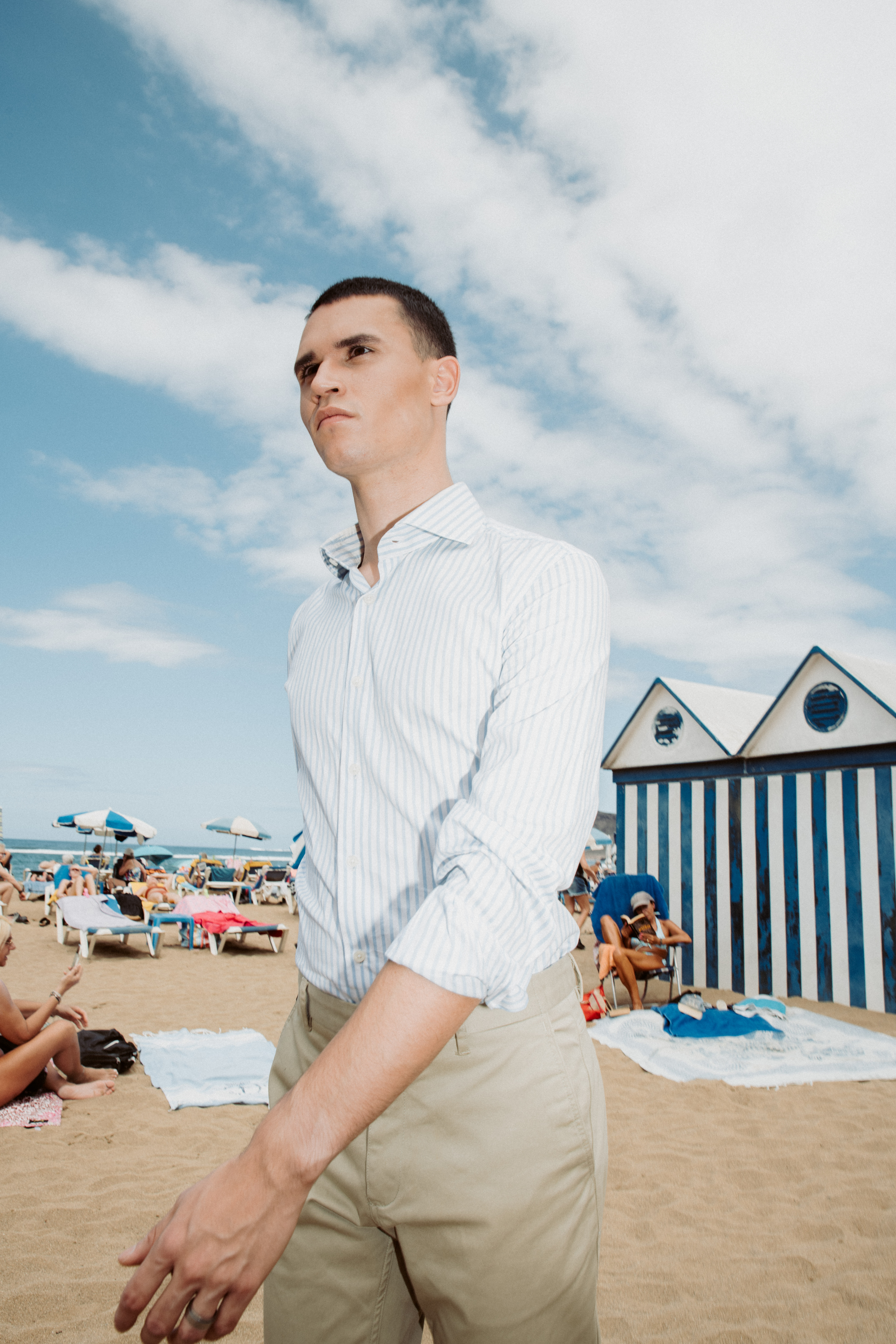 Modelo bajo el sol con camisa de manga larga y pantalón de vestir en un editorial de moda en Canarias