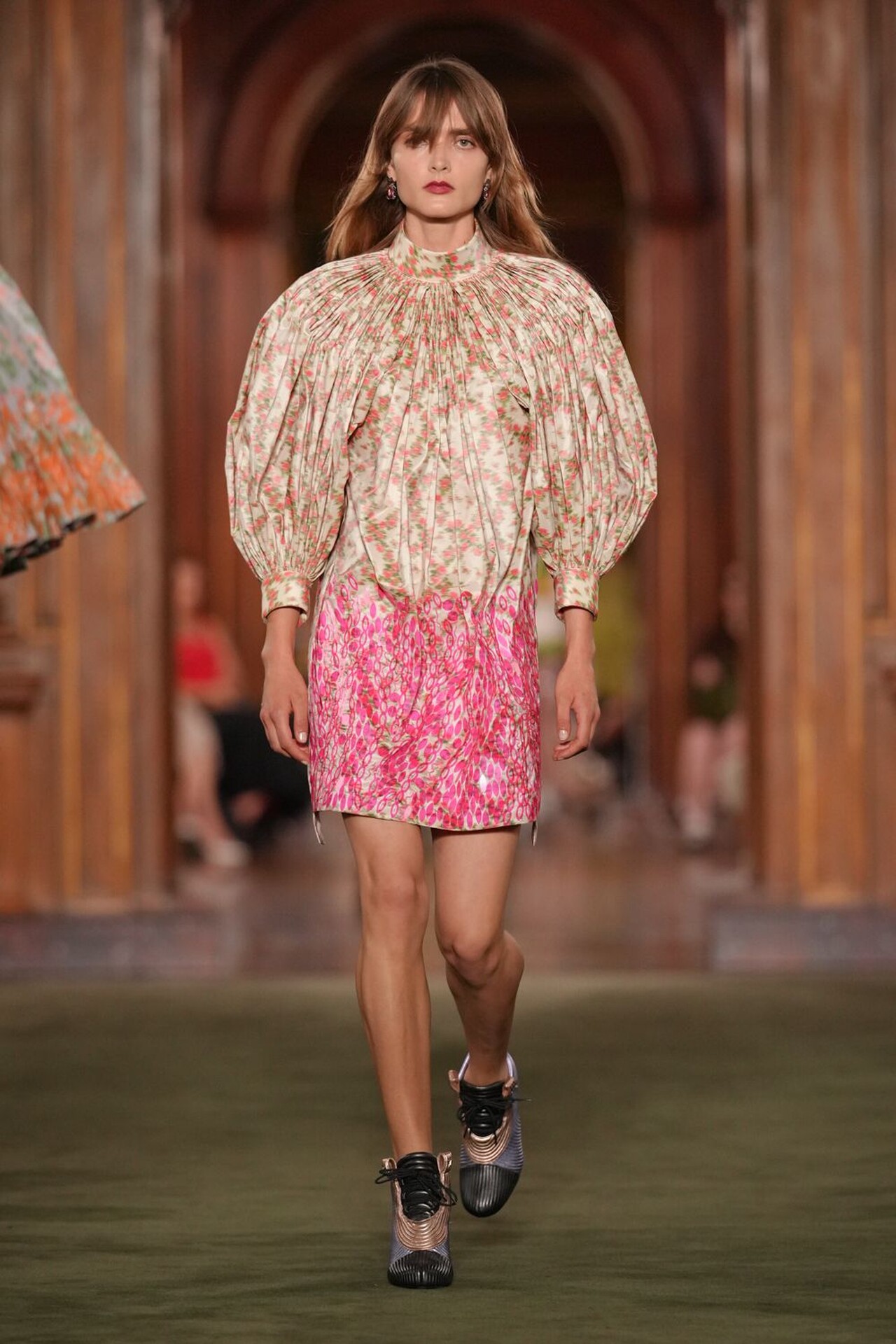 Modelo con estilismo urbano y detalles históricos en el desfile Louis Vuitton Cruise 2027