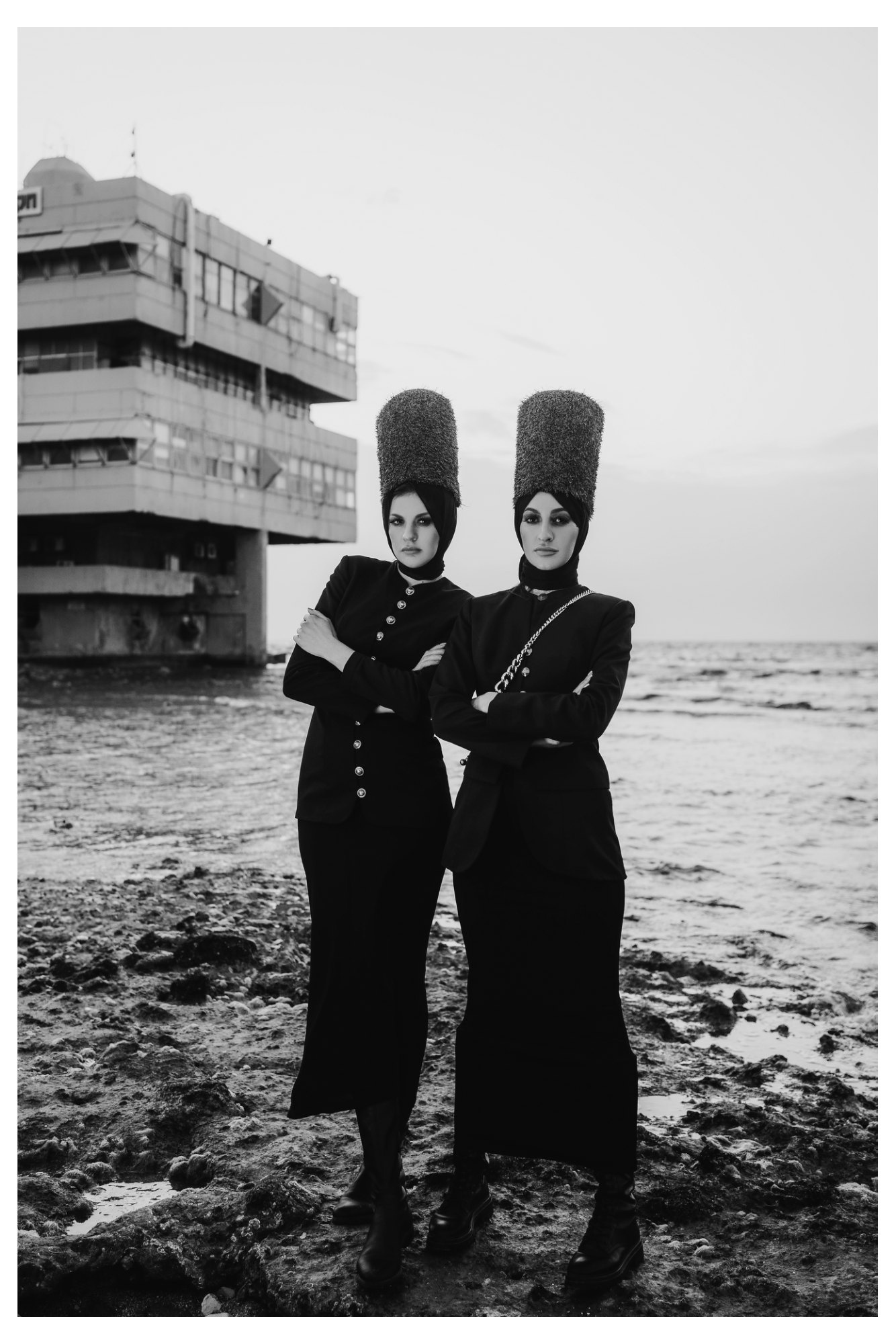 Two women wearing structured dramatic crinolines and towering hats in a fashion editorial